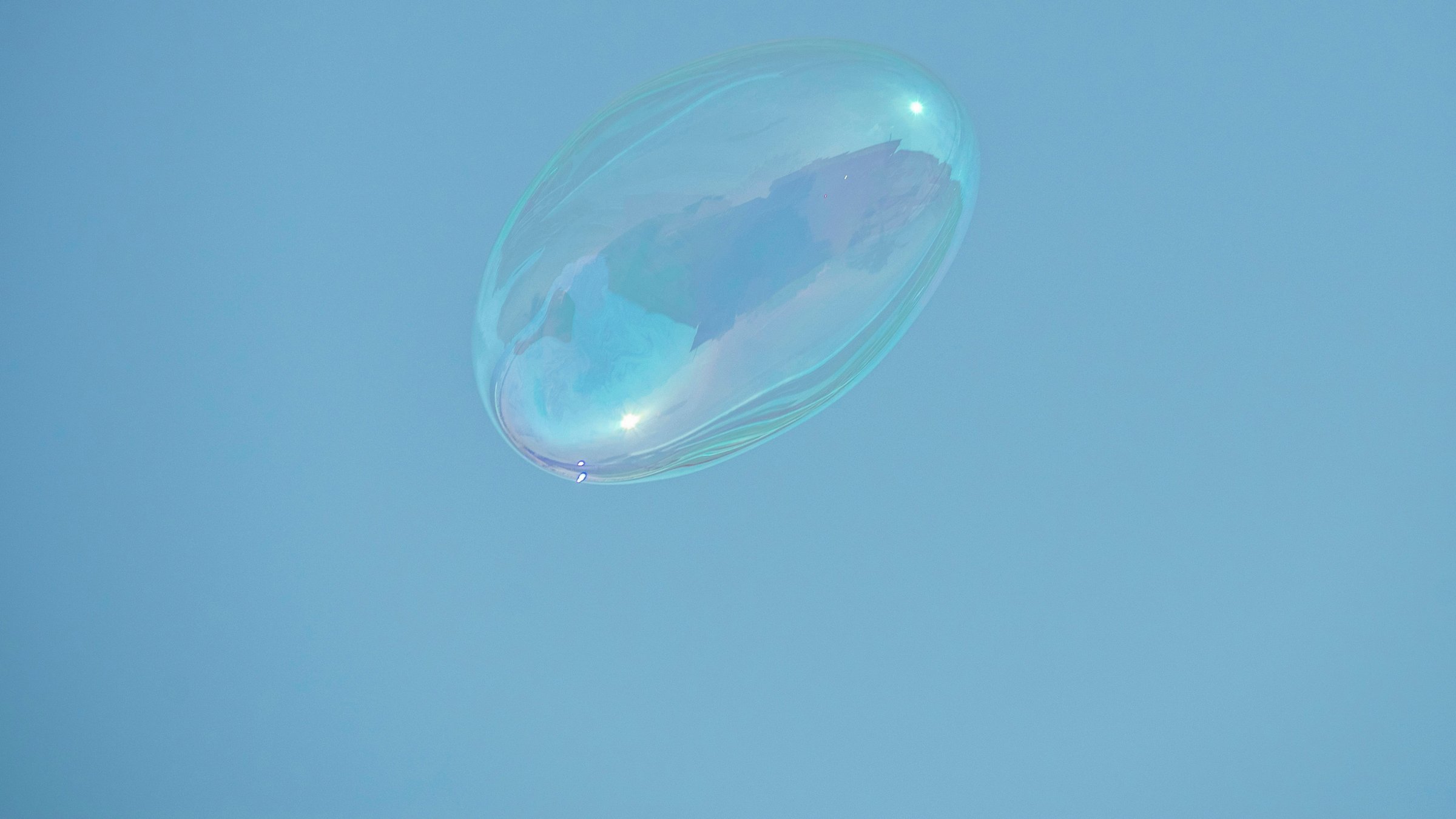 A soap bubble floating in a clear blue sky, the image from the Beautiful Thinking home page