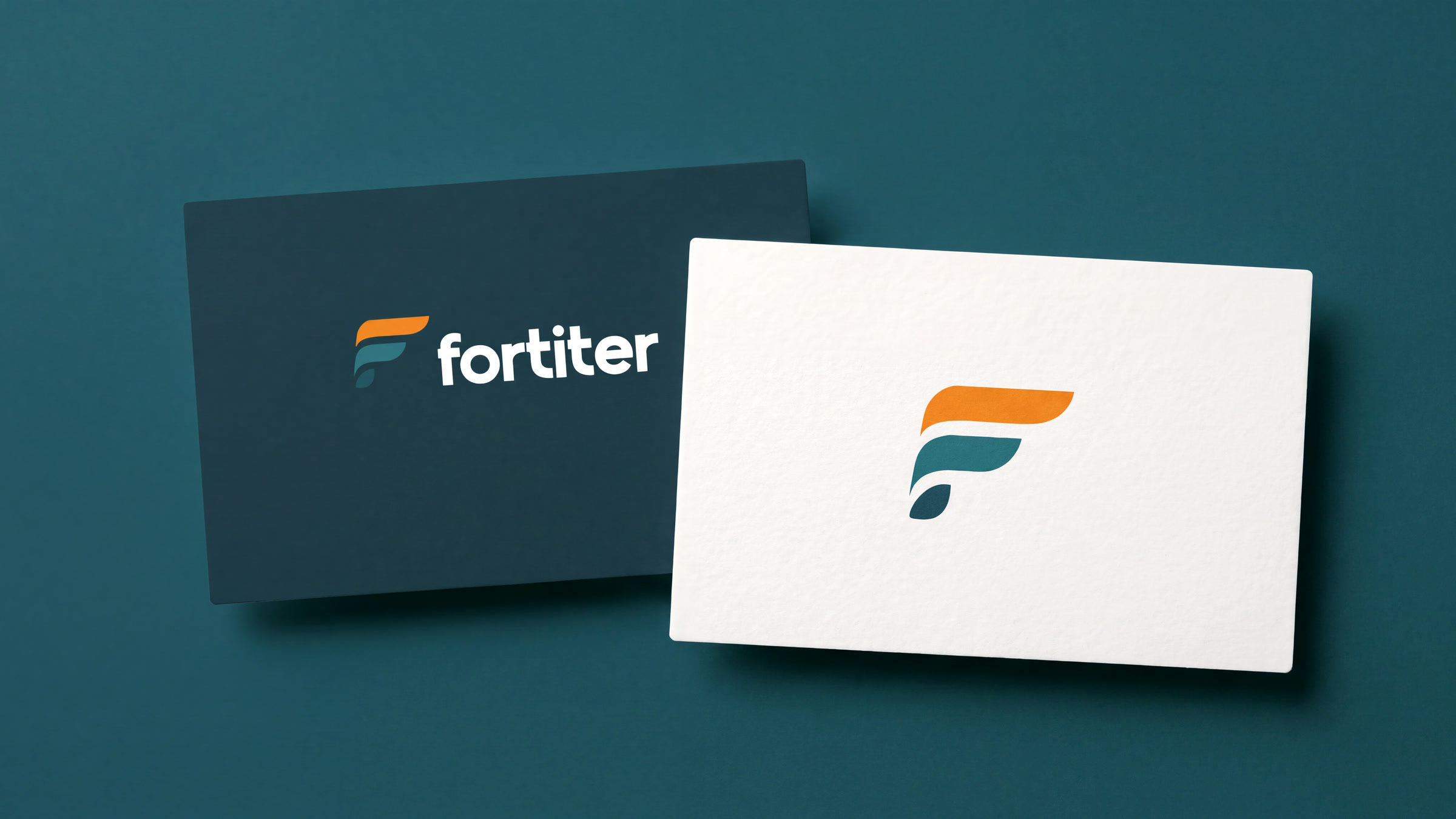 Mockup of two cards on mid teal: the reverse Fortiter logo on deep slate, and the colour F on off-white