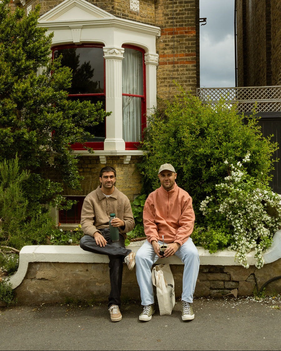 Two people sitting on a garden wall with a mate gourd
