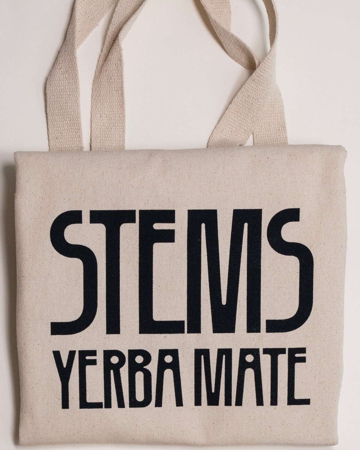 The canvas Stems Yerba Mate tote bag laid flat