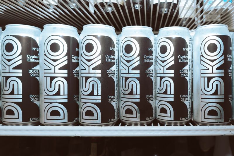 Disko № 6, Zurich by Hans Frauchiger and Noé Rogger: Packaging: the narrow inline wordmark runs the full height of each can; silver and black, a row of six reads as one pattern