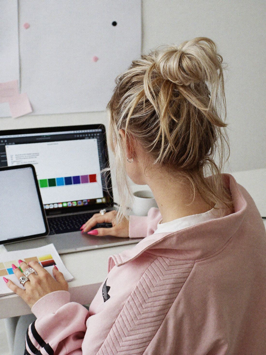 Sophie Evans working at a laptop with a colour palette on screen and printed swatches in her hand