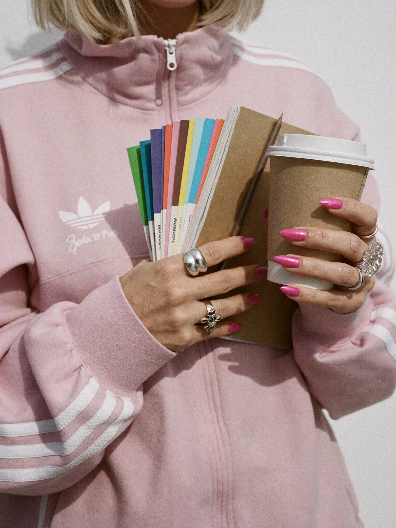 Sophie Evans holding a fan of colour swatches and a coffee