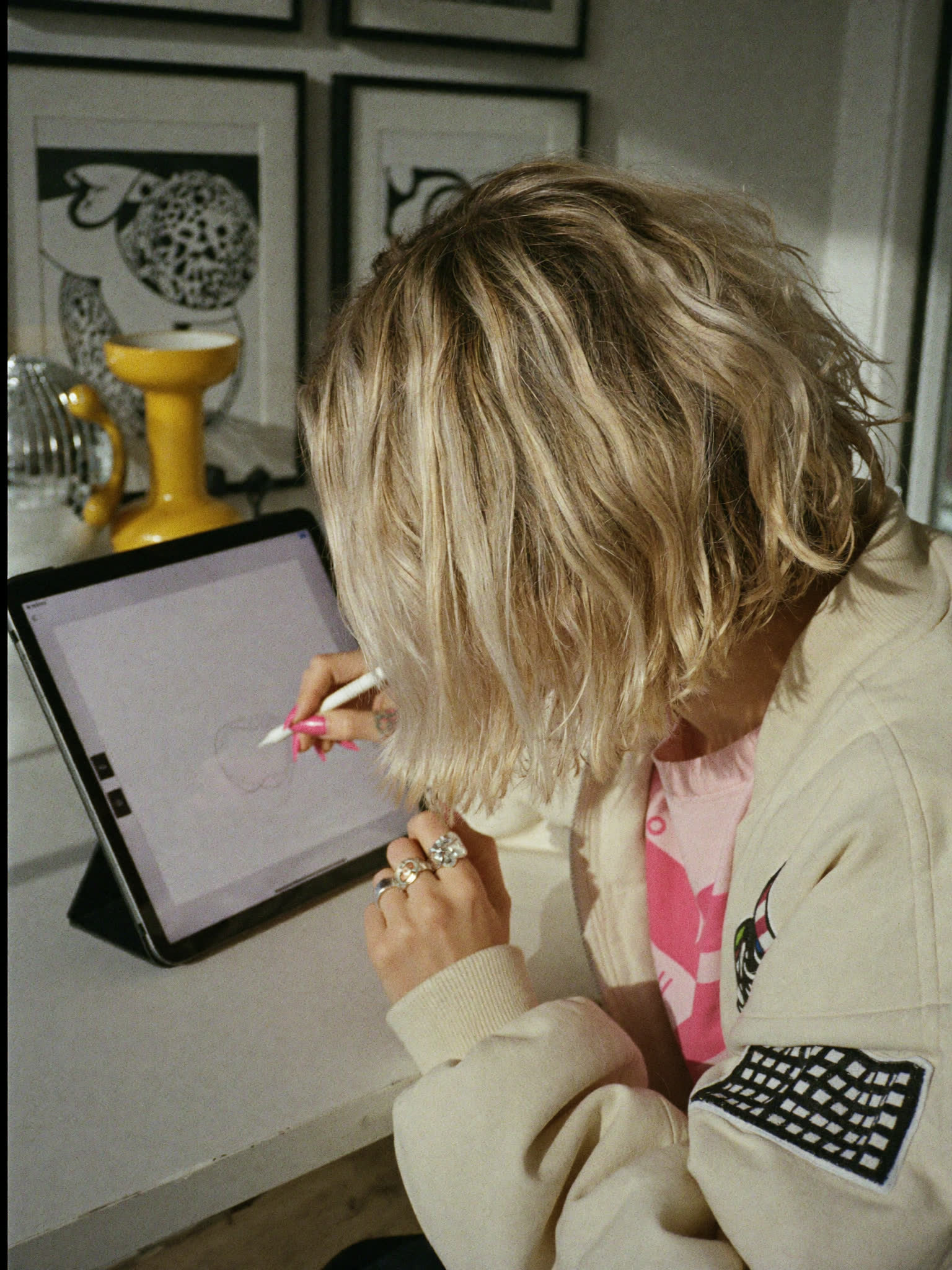 Sophie Evans sketching on an iPad at her studio desk, her face turned away